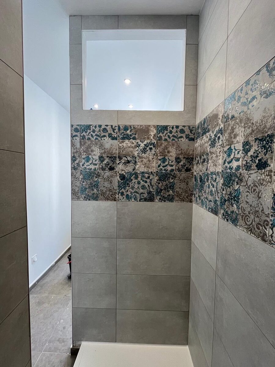 Bathroom tiling with large-format grey porcelain tiles and floral decorative band, Brighton
