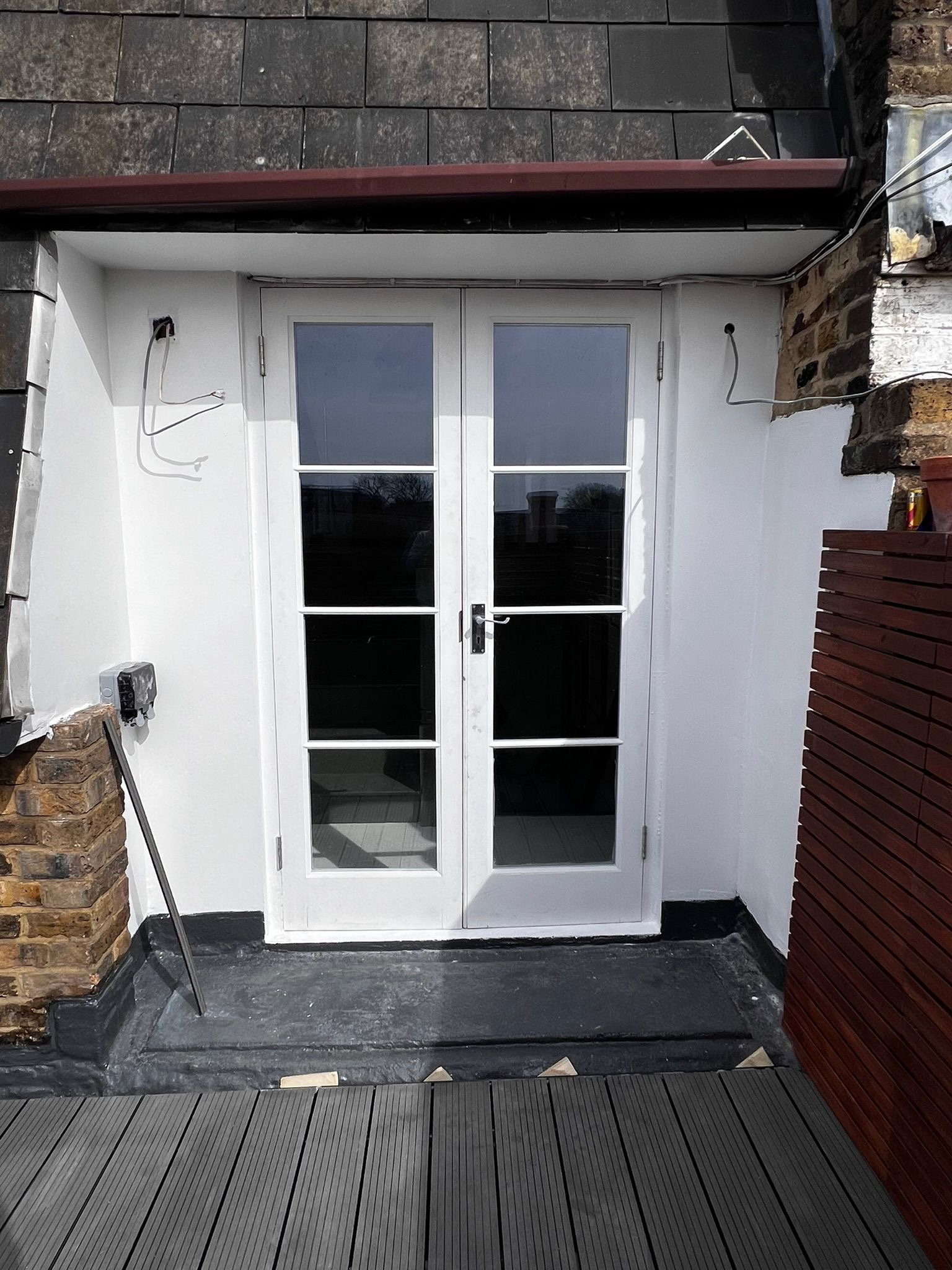 French doors opening onto rooftop terrace with timber screening