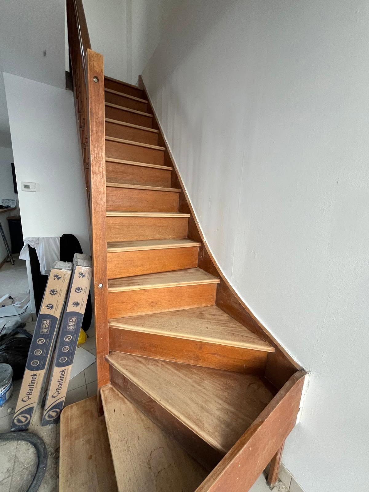 Staircase after renovation — new timber treads fitted, carpet removed, Barlinek flooring boards on site, Brighton property