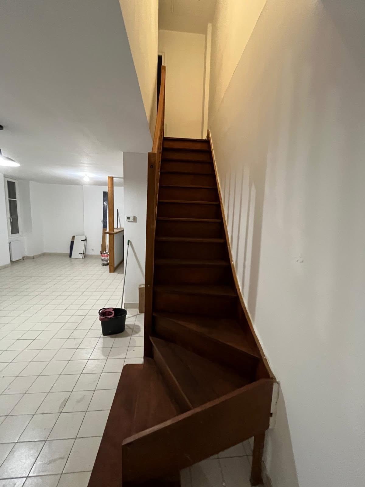 Staircase in original condition before renovation — dark worn timber treads, white walls, open plan area below, Brighton property